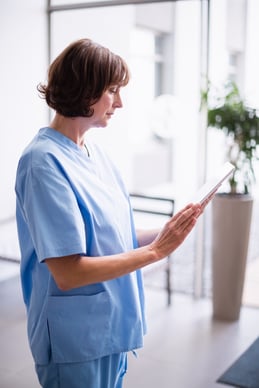 verpleegkundige vult patiëntengegevens aan op de tablet